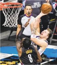  ?? JOHN MINCHILLO AP ?? Mavericks point guard Luka Doncic, who finished with 27 points and one turnover, shoots over the Nets’ Jeff Green.