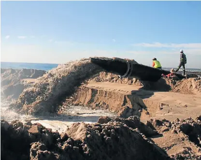  ?? /Tony Carnie ?? Shifting sand: Sea water and sand gush from a sandpumpin­g pipeline in Durban. Many fear that continued smothering of Vetch’s Pier is destroying marine assets.