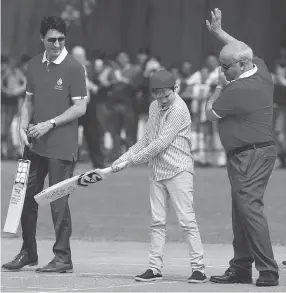  ?? MANISH SWARUP / THE ASSOCIATED PRESS ?? Prime Minister Justin Trudeau, left, watches his son Hadrien play cricket during the family’s visit to a school in New Delhi, India, on Thursday.