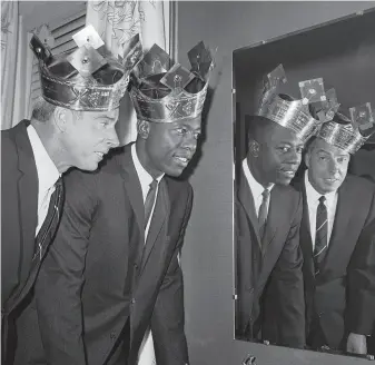  ?? William A. Smith / Associated Press 1964 ?? Scott Ostler says Hank Aaron was his generation’s Joe DiMaggio. Here they’re wearing “Sultan of Swat” crowns in 1964. Dodgers announcer Vin Scully, however, called Aaron “Bad Henry.”