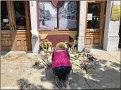  ?? BONNIE MEIBERS/STAFF ?? Annette Gibson-Strong heard the bars on East Fifth Street planned to open Monday, so she came to move the memorials from the doors to make sure nothing would get thrown away.