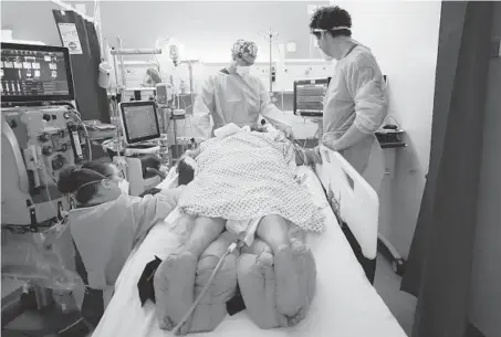  ?? KIRSTY WIGGLESWOR­TH/AP ?? Critical care staff looks after a COVID-19 patient at King’s College Hospital in London.