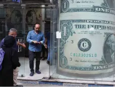  ?? EPA ?? A US dollar display at an exchange bureau in Cairo. A trend towards a weakening US economy has hit the currency