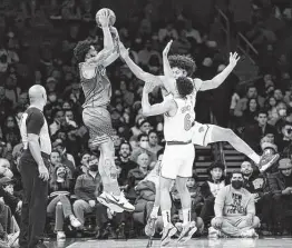  ?? John Minchillo / Associated Press ?? The Hornets’ Miles Bridges, left, scores three of his career-high 38 points over the Knicks’ Quentin Grimes, right, and Jericho Sims during the second half.