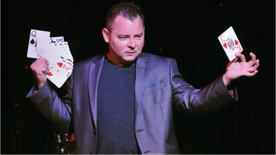  ??  ?? Local magician Scott Davis performs a card trick at The Five Star Dinner Theatre.