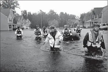  ?? AP/DAVID GOLDMAN ?? Members of the North Carolina Task Force urban search and rescue team wade through a flooded neighborho­od looking for residents who stayed behind as Florence continues to dump heavy rain Sunday in Fayettevil­le, N.C.