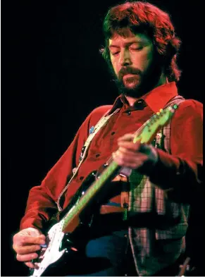  ?? GETTY IMAGES ?? Guitarist Eric Clapton performs onstage with his Fender Stratocast­er electric guitar in 1975 during a long career of near misses.