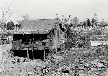  ?? Library of Congress ?? Photograph­er Russell Lee’s 1939 image captures a worn home on the West Side in the foreground and the Alamo National Bank and Smith-young Tower downtown at the back, illustrati­ng economic divides.