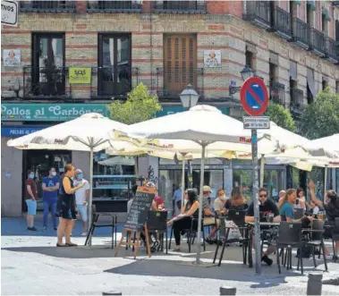  ??  ?? Las terrazas de Madrid presentaro­n durante toda la mañana la misma estampa: llenas y con gente esperando su turno. Aquí, la Plaza de Cascorro.