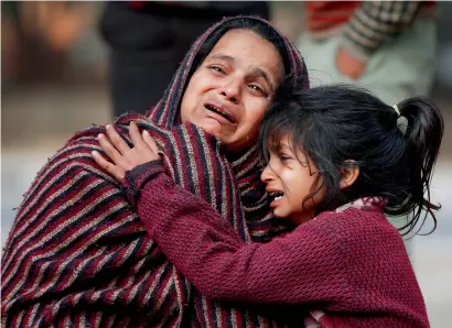  ?? — Reuters ?? Relatives of a victim, who was killed in Saturday’s fire in a warehouse, mourn as they wait outside a hospital in New Delhi on Sunday.