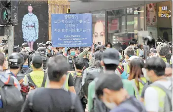  ?? — AFP photos ?? Police officers put up a banner telling people to disperse during China’s National Day in Hong Kong.