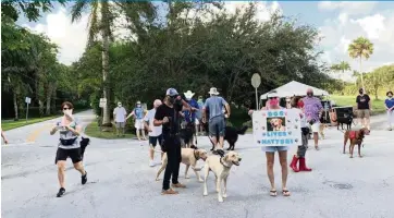  ??  ?? Dog owners protest closure of West Matheson Hammock Park’s north entrance during a weekend rally at their favorite outdoor hangout.