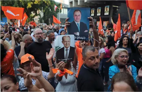  ?? Reuters ?? Supporters of Lebanon’s Free Patriotic Movement carry flags and placards outside the party’s office in Sin El Fil on Tuesday