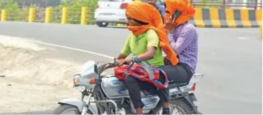  ?? Agence France-presse ?? ↑ Motorists cover their faces with cloth while travelling on a hot summer day in Amritsar, Punjab, on Sunday.