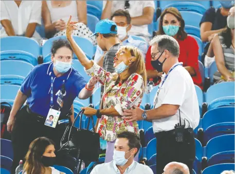  ?? ASANKA BRENDON RATNAYAKE/REUTERS ?? A fan flashes one final hand gesture toward Spanish star Rafael Nadal as she's escorted out of Rod Laver Arena by security personnel during action at the Australian Open on Thursday. Nadal advanced with a solid victory over American Michael Mmoh.