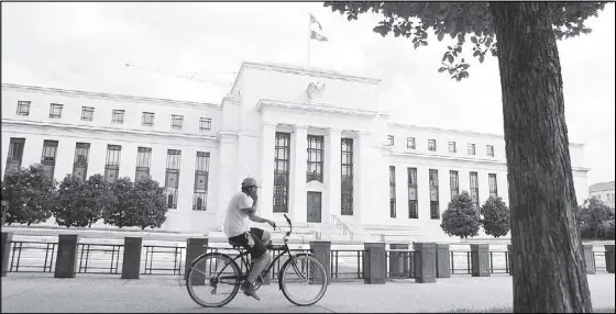  ?? REUTERS ?? A cyclist passes the Federal Reserve building in Washington, DC, US.