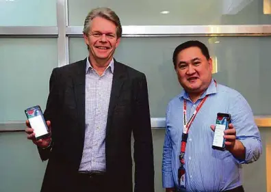  ??  ?? (Globe Senior Advisor for Enterprise and IT Enabled Services Group Mike Frausing (left) and Phoenix Petroleum AVP for IT Alfred Reyes (right) display G Suite on their mobile devices.