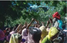  ?? — AFP ?? Rohingya refugees from Myanmar gather around a truck delivering clothes in Ukhia.