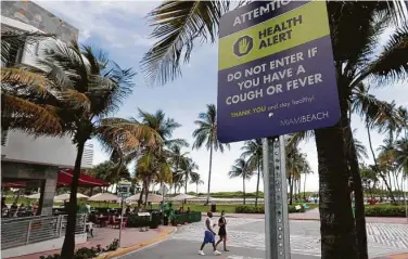  ?? Wilfredo Lee / Associated Press ?? A sign asks people not to visit Florida’s Miami Beach if they have a cough or fever.