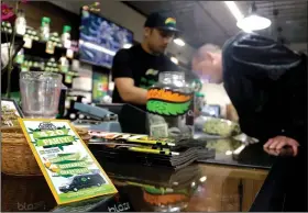  ?? AP/DON RYAN ?? Tyler Kennedy (right) smells a marijuana sample from Noah Siialata at CannaDaddy’s Wellness Center marijuana dispensary in Portland, Ore. Thousands of studies since 1999 have found examples of marijuana or individual compounds found in the plant...