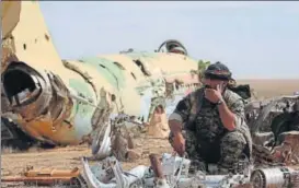  ?? REUTERS ?? A Syrian Democratic Forces fighter rests near destroyed airplane parts inside Tabqa military airport n after taking control of it from Islamic State fighters, west of Raqqa city, Syria.