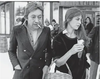  ?? FOTO: AFP ?? Sie kauft Essen, er raucht: Serge Gainsbourg und Jane Birkin 1977 in Avoriaz. Acht Jahre zuvor waren beide über Nacht zu Weltstars geworden, mit dem Lied „Je t‘aime, ... moi non plus“, das damals für einen Skandal gesorgt hatte.