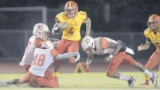  ?? MICHAEL LAUGHLIN/SOUTH FLORIDA SUN SENTINEL ?? Deerfield Beach’s Jaylan Knighton challenges three Plantation defenders during the second half of their 8A football regional semifinal game on Nov. 16, 2018, at Deerfield Beach High School.