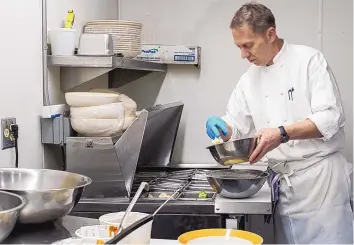  ?? ADOLPHE PIERRE-LOUIS/JOURNAL ?? Chef Chris Pope makes tempura-fried veggies in the cellar bar kitchen.