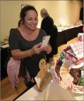  ?? Dan Watson/The Signal ?? Joanne Cammarata takes photos of a gingerbrea­d house Saturday during the festival.