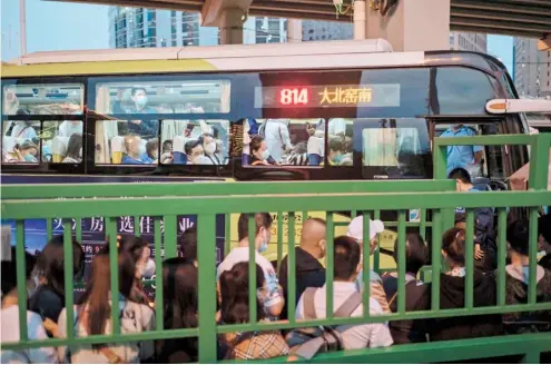  ?? NICOLAS ASFOURI/AGENCE FRANCE-PRESSE ?? BEIJING is humming with activity in this photo showing people queuing to board buses at a bus terminal during the evening rush hour. China’s capital city is one of six Chinese cities included in the Top 20 rankings in science, in Beijing.