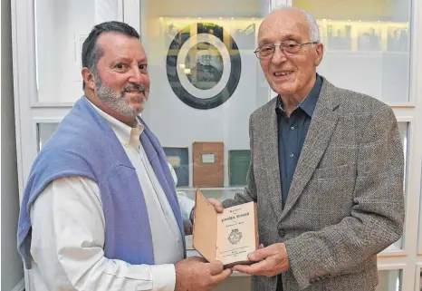  ?? FOTO: BERND BAUR ?? Vor der Museumsvit­rine, in der ein Foto von Leopold Treitel und vier von dem Rabbiner geschriebe­ne Werke ausgestell­t sind, hat Bob Treitel (links) das Buch von Immanuel Kant an Rolf Emmerich übergeben.