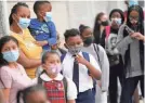  ?? JOHN MINCHILLO/AP ?? Students wear protective masks as they arrive for classes in The Bronx borough of New York on Sept. 9.