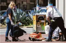  ?? Jessica Christian / The Chronicle 2021 ?? Crisis Response Team members check in with a man in distress near Sixth and Market streets last May. Mental illness is one of the factors keeping people living on the streets, but a new center seeks to provide resources and follow-up.