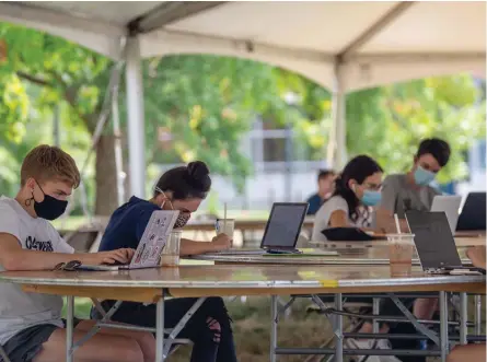  ??  ?? Masked students study in an outdoor dining tent on the Student Union Mall at the University of Connecticu­t (UConn) main campus in Storrs on September 9, 2020. The tents were placed to provide an open-air spot for studying, dining, and physical distancing during COVID-19. Photo: Sean Flynn/UConn