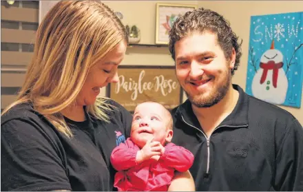  ?? MILLICENT MCKAY/JOURNAL PIONEER ?? Paizlee Rose Adams, centre, seven-months, smiles up at her mom Emily McCardle and father Andy Adams. The happy parents brought their daughter home at the end of October after spending several months in various hospitals. Paizlee was born at 23 weeks at the IWK Health Centre in April.