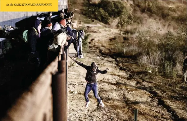  ?? DANIEL OCHOA DE OLZA / THE ASSOCIATED PRESS ?? A migrant jumps the border fence to get onto the U.S. side from Tijuana, Mexico, on Tuesday, as the U.S. government standoff over border wall funding continued.