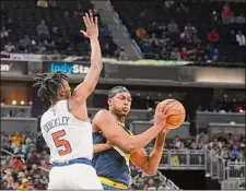  ?? Darron Cummings / Associated Press ?? Indiana’s Myles Turner, right, is defended by New York’s Immanuel Quickley. Turner hit seven of 10 3-pointers.