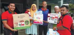  ??  ?? theSun's representa­tives handing items to Nur Izzati and her brother Mohd Bukhari. With them is Was Padang Menora JKKK chief Ramli Abdul Razak (second from right).