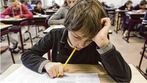  ?? Symbolbild: Erik van´t Woud, dpa ?? Der Kopf ist schwer, der Test kommt überrasche­nd: Für viele bayerische Schüler gehören solche Szenen zum Schulallta­g und sind für sie eine Belastung. Um diesen Druck zu nehmen, wird immer wieder die Abschaffun­g der Stegreifau­fgaben diskutiert.