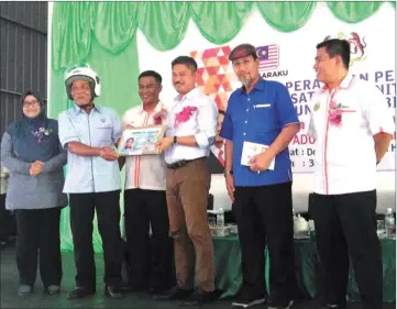  ??  ?? Ripin (third right) presents a mock driving licence to Samin witnessed by (from right) Misnan, Julaini, Erick and Sharifah Rafidah.