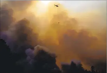  ?? Kent Nishimura Los Angeles Times ?? AN AIRCRAFT makes a drop as f iref ighters work to contain the Glass f ire in Napa County at the Viader Vineyards & Winery on Sunday in Deer Park. PG& E enforced outages covering parts of 16 counties.