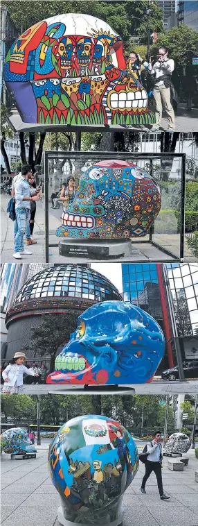  ??  ?? Mujeres toman fotos de una calavera multicolor pintada por el artista José Esteban Martínez. La gente mira un cráneo de colores pintado por el artista Ignacio Villanueva Aguirre. Una niña mira una calavera que es obra de la artista Lola Argemi y se...