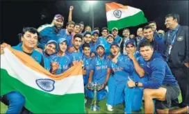  ?? PTI PHOTO ?? The Under19 cricket team and coach Rahul Dravid celebrate with the trophy.