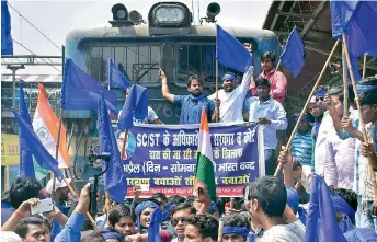  ?? — PTI ?? (above) Bhim Army Sena members stop a train during Bharat Bandh call given by Dalit organisati­ons against the alleged dilution of the Scheduled Castes and Scheduled Tribes act, in Patna. (right) An injured student is being taken care by the fellow students at Women’s College Science Block in Patna.