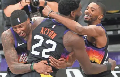  ?? MICHAEL CHOW/THE REPUBLIC ?? Phoenix Suns center Deandre Ayton is hugged by forwards Torrey Craig (left) and Mikal Bridges after his game-winning dunk against the LA Clippers during Game 2 at Phoenix Suns Arena on Tuesday.