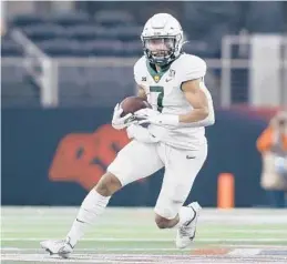  ?? TIM HEITMAN/AP ?? Baylor running back Abram Smith runs the ball against Oklahoma State in the second half of the Big 12 Conference championsh­ip game on Dec. 4 in Arlington, Texas.