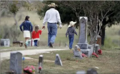  ?? ASSOCIATED PRESS ?? A family arrives for a grave side service for Richard and Therese Rodriguez at the Sutherland Springs Cemetery, Saturday in Sutherland Springs, Texas. The Rodriguez couple were killed when a man opened fire inside the Sutherland Springs First Baptist...