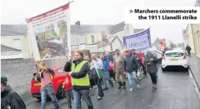  ??  ?? &gt; Marchers commemorat­e the 1911 Llanelli strike