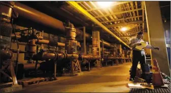  ?? (File Photo/AP/Gregory Bull) ?? Technician John Irving works on a valve May 8, 2015, inside the city’s water reclamatio­n plant in San Diego.