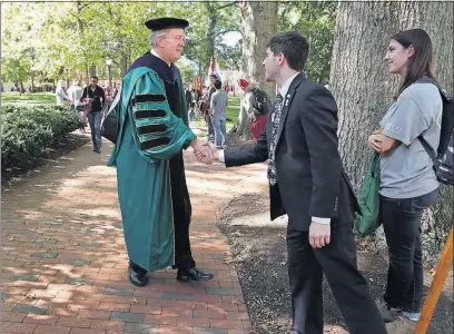  ?? [ERIC ALBRECHT/DISPATCH] ?? New Ohio University President M. Duane Nellis greets students as he walks from the Baker University Center to the Templeton-Blackburn Alumni Memorial Auditorium for his investitur­e on Wednesday.